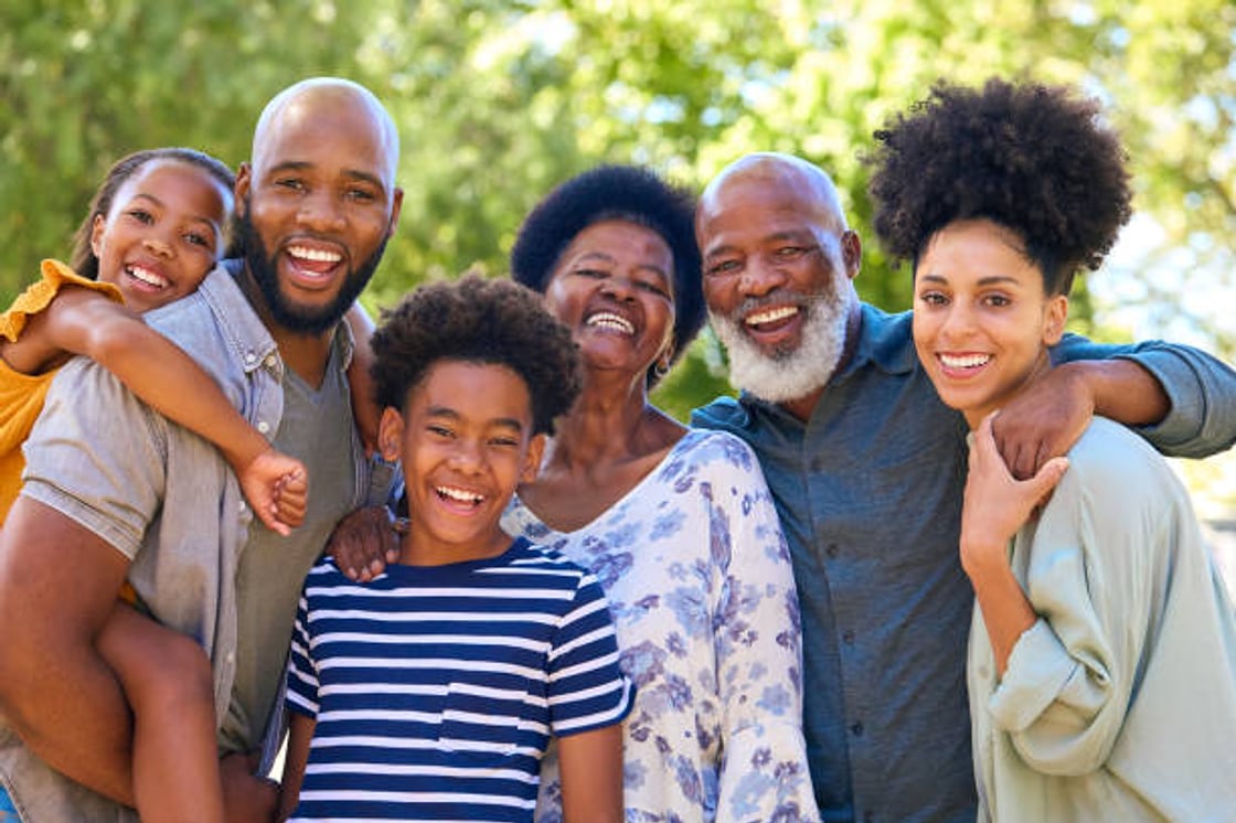 Three generations of a happy family laughing together outdoors